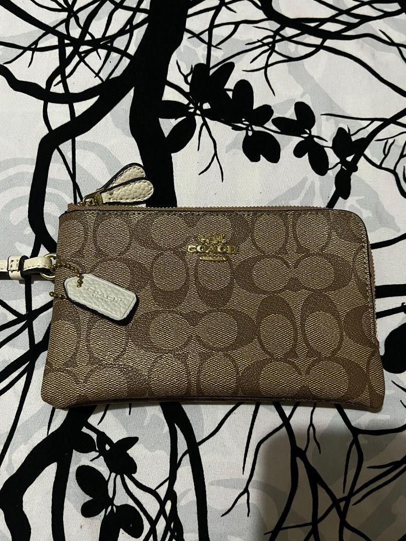 Coach Signature Double Zip Wristlet Pouch (Category: Luxury Bags & Wallets) located in Infanta. Submitted by izzy2shop (Listing ID 1461113377, Image 1). Description: - Coach wristlet pouch - Signature C pattern - Two zippered compartments - Gold hardware - Detachable wrist strap - Ideal for cards, cash, and phone - Compact and easy to carry.
