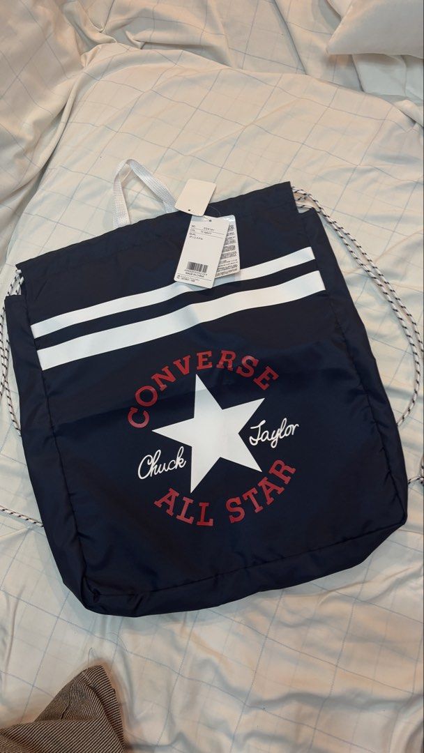 Converse Chuck Taylor All Star Navy Drawstring Bag (Category: Backpacks) located in Manila. Submitted by mamajho08 (Listing ID 1461029366, Image 3). Description: - Navy blue Converse drawstring bag - Features classic Chuck Taylor All Star logo (red & white) - Two white stripes across the front - Secure drawstring closure - Convenient white top handles - Brand new with original tags attached - Ideal for gym sessions or everyday errands.