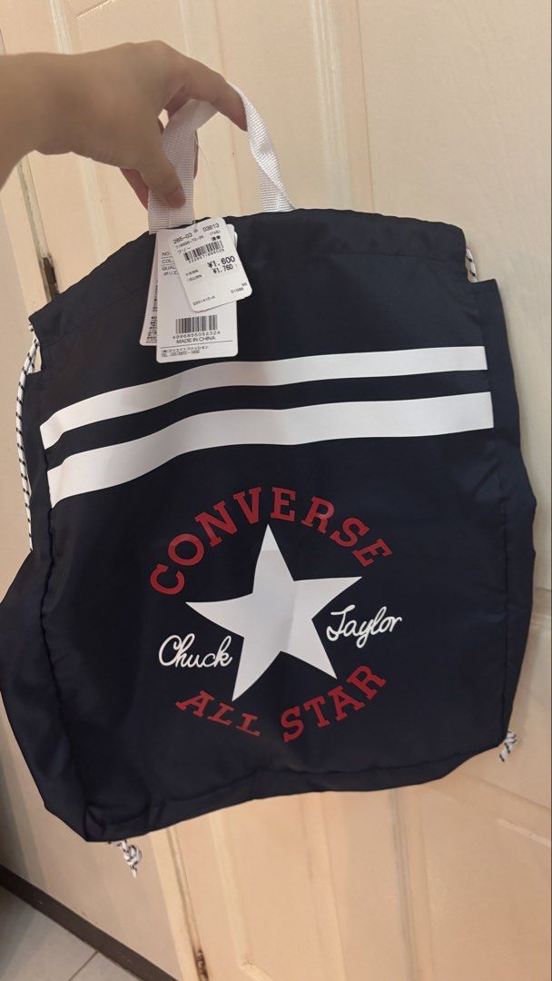 Converse Chuck Taylor All Star Navy Drawstring Bag (Category: Backpacks) located in Manila. Submitted by mamajho08 (Listing ID 1461029366, Image 1). Description: - Navy blue Converse drawstring bag - Features classic Chuck Taylor All Star logo (red & white) - Two white stripes across the front - Secure drawstring closure - Convenient white top handles - Brand new with original tags attached - Ideal for gym sessions or everyday errands.