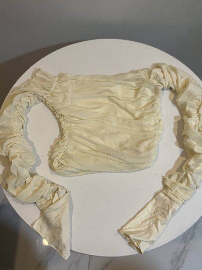Cream Ruched Mesh Long Sleeve Top (Category: Longsleeves) located in Manila. Submitted by xoshushi.dcltr (Listing ID 1460974351, Image 1). Description: - Cream mesh top - Ruched detailing all over - Long sleeves with flared cuffs - Off-the-shoulder style - Very sheer material - Ideal for layering or a night out.