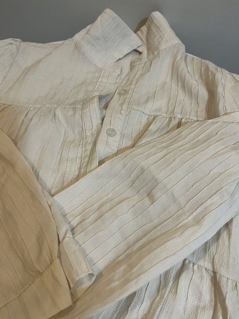 Cream Textured Button-Up Shirt (Category: Longsleeves) located in Manila. Submitted by xoshushi.dcltr (Listing ID 1460974986, Image 3). Description: - Cream colored shirt - Textured fabric - Long sleeves with button cuffs - Button-up front with collar - Relaxed fit - Versatile: great for layering or wearing alone.
