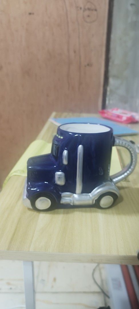 Delo Truck Ceramic Mug (Category: Coffee & Tea Tableware) located in Manila. Submitted by silverwhale_cafa21 (Listing ID 1461038309, Image 2). Description: - Unique mug shaped like a Delo truck - Dark blue color with silver accents - Features a convenient side handle - Ideal for enjoying coffee or tea - A must-have for truck enthusiasts and collectors.