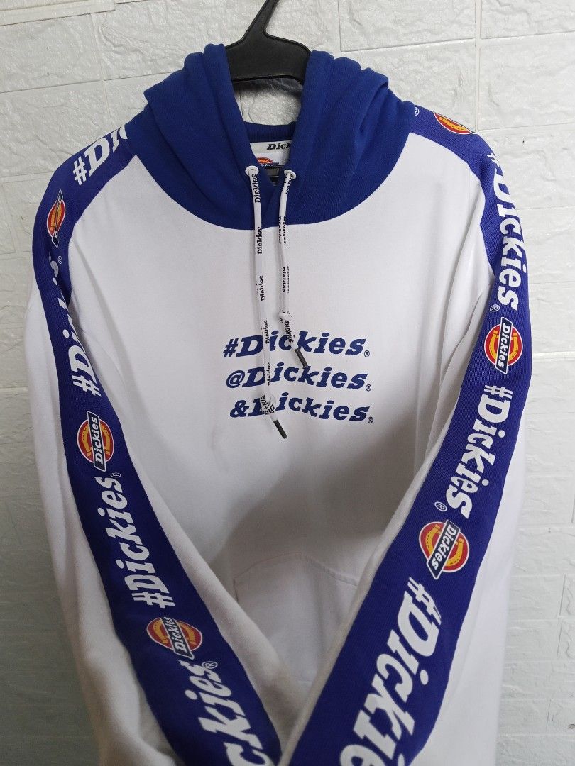 Dickies White Blue Graphic Hoodie (Category: Hoodies) located in Apalit. Submitted by grandocean.69bd38 (Listing ID 1461029544, Image 2). Description: - Dickies Hoodie - Color: White with Blue Accents - Size: Large (L) - Features Dickies logo and social media handles on the front - Dickies logo tape detail down the sleeves - Blue hood with adjustable drawstrings Size: Large on tag Dimes: 23 x 30 Verygood Condition Mine: 750.
