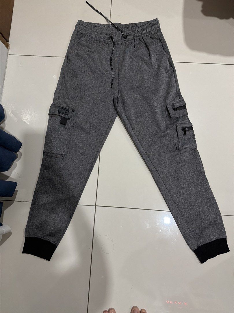 Encrypted Grey Cargo Jogger Pants Size S (Category: Joggers) located in Rizal. Submitted by macristina33105 (Listing ID 1461026431, Image 1). Description: - Grey cargo jogger pants by Encrypted - Elastic waistband with adjustable drawstring - Multiple functional pockets on legs, including one with a zipper - Cuffed ankles for a modern jogger look - Designed for a comfortable, everyday fit.