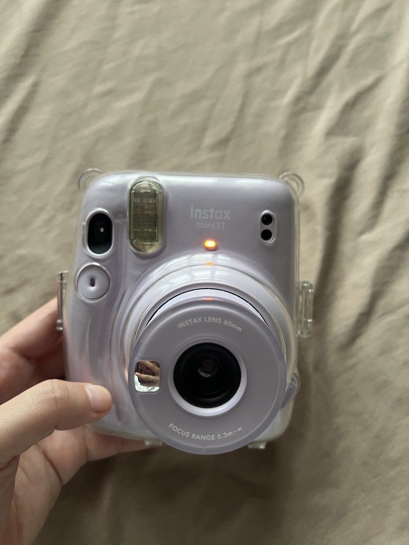 Fujifilm Instax Mini 11 Lavender Instant Camera (Category: Cameras) located in Valenzuela. Submitted by decluttering.manila (Listing ID 1461002943, Image 2). Description: - Lavender Fujifilm Instax Mini 11 camera - Comes with a clear protective case - Includes a wrist strap - 60mm lens with focus range from 0.3m to infinity - Ideal for capturing instant memories - Fully functional and works well.
