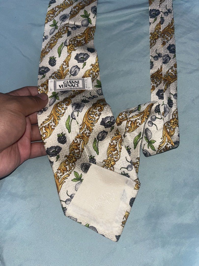Gianni Versace Silk Tie (Category: Ties) located in Tabuk. Submitted by collectors_thrift_shop (Listing ID 1461019885, Image 3). Description: - Authentic Gianni Versace tie - Cream base with gold baroque pattern - Features fruit and flower motifs - Made of 100% Silk - Ideal statement piece for formal or casual outfits.