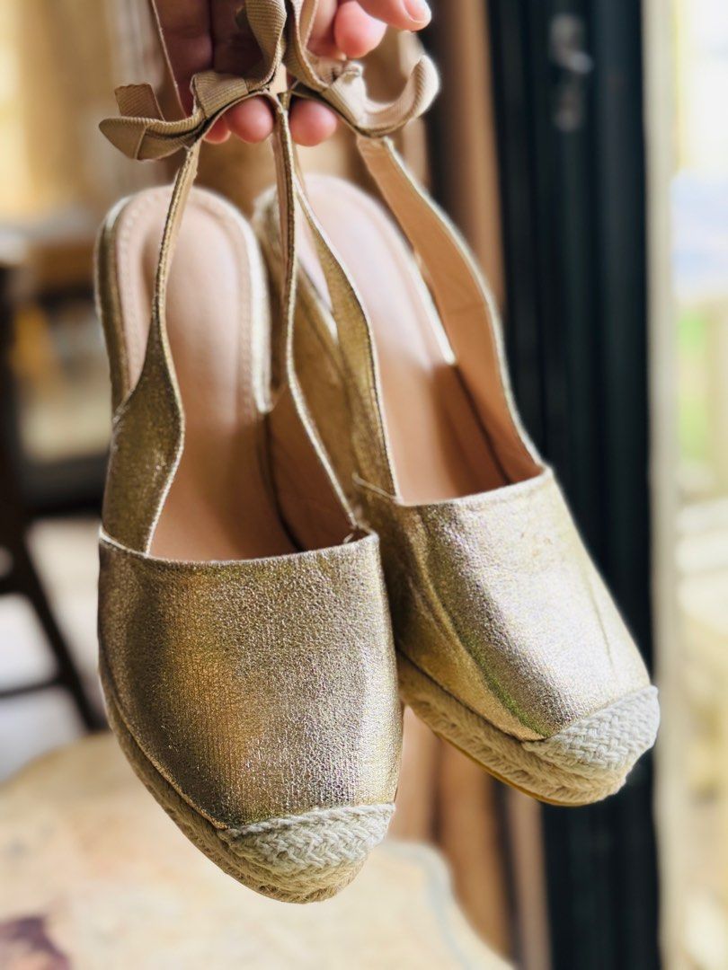Gold Metallic Espadrille Wedge Slingback Heels (Category: Wedges) located in Bacolod City. Submitted by vintage_vogue6100 (Listing ID 1460980539, Image 1). Description: - Gold metallic espadrille wedge heels - Slingback style with tie-up ankle ribbons - Trendy square toe design - Comfortable wedge heel with natural jute detailing - Versatile: dress up or down - Ideal for summer occasions.