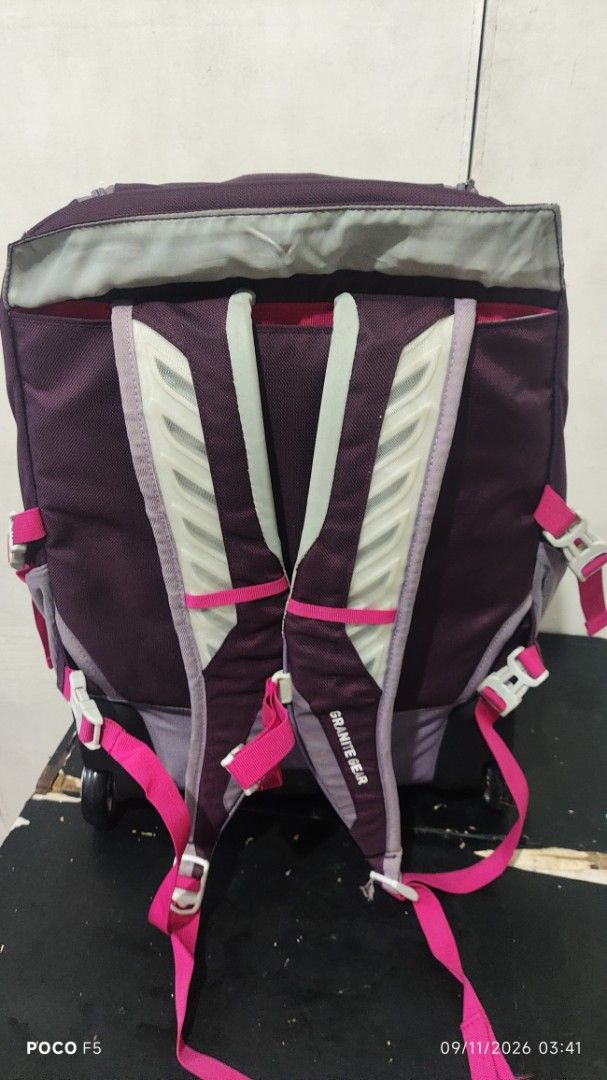 Granite Gear Rolling Backpack Luggage Purple Pink (Category: Backpacks) located in Quezon City. Submitted by ralphralph (Listing ID 1460984972, Image 3). Description: - Granite Gear rolling backpack - Color: Purple, grey, and pink accents - Features wheels and retractable handle for easy transport - Includes padded shoulder straps - Multiple compartments for organized storage - Note: Minor marks on the pink strap near the zipper.