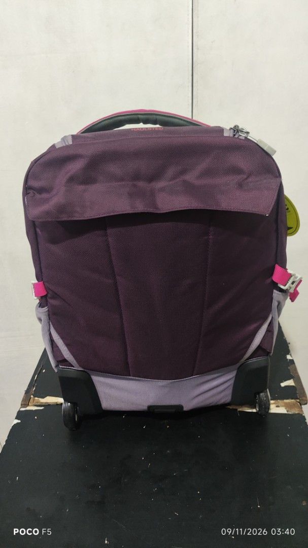 Granite Gear Rolling Backpack Luggage Purple Pink (Category: Backpacks) located in Quezon City. Submitted by ralphralph (Listing ID 1460984972, Image 2). Description: - Granite Gear rolling backpack - Color: Purple, grey, and pink accents - Features wheels and retractable handle for easy transport - Includes padded shoulder straps - Multiple compartments for organized storage - Note: Minor marks on the pink strap near the zipper.