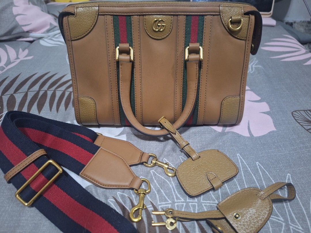 Gucci Bauletto (Category: Luxury Bags & Wallets) located in Makati City. Submitted by mccoooy (Listing ID 1461002460, Image 1). Description: - Authentic brown leather Gucci bag - Signature green and red stripe detail - Gold hardware - Detachable shoulder strap - Includes luggage tag and lock with keys - Interior zip pocket - Serial number visible inside.