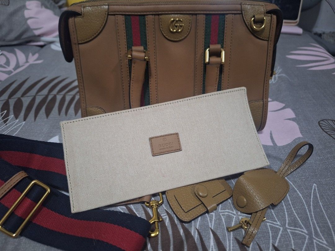 Gucci Bauletto (Category: Luxury Bags & Wallets) located in Makati City. Submitted by mccoooy (Listing ID 1461002460, Image 2). Description: - Authentic brown leather Gucci bag - Signature green and red stripe detail - Gold hardware - Detachable shoulder strap - Includes luggage tag and lock with keys - Interior zip pocket - Serial number visible inside.