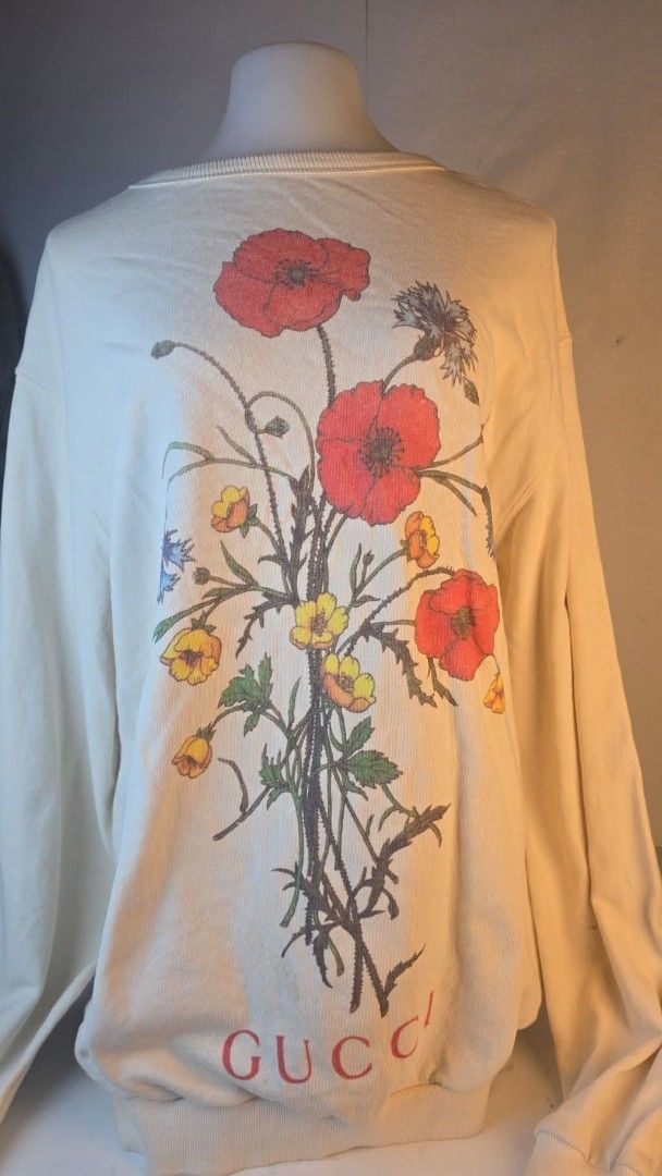 Gucci Floral Print Sweatshirt (Category: Luxury Apparel) located in Pasig City. Submitted by dertah (Listing ID 1461037287, Image 2). Description: - Cream colored sweatshirt - Beautiful floral print on the front - Visible Gucci logo at the bottom - Red graphic on the back with "Chateau Marmont Hollywood" text - Ideal for fashion enthusiasts.