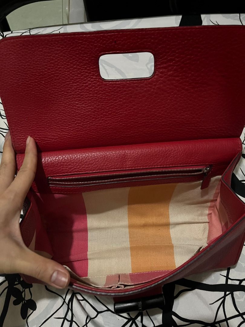 Gucci Red Leather Clutch Bag (Category: Luxury Bags & Wallets) located in Infanta. Submitted by izzy2shop (Listing ID 1461113240, Image 2). Description: - Genuine red leather Gucci clutch - Interior features classic striped fabric lining - Secure zipper closure - Embossed Gucci logo and serial number inside - Includes 'GU F1234' tag - Convenient exterior slip pocket - Ideal for evening events or as a stylish statement accessory.