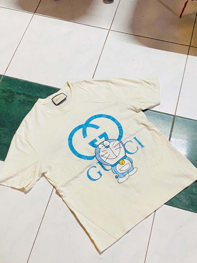 GUCCI x DORAEMON Oversized T-Shirt — White/Blue (Category: Shirts) located in San Isidro, Davao Oriental. Submitted by ranofrehets (Listing ID 1461101794, Image 1). Description: 🐱💙 GUCCI x DORAEMON Oversized T-Shirt — White/Blue 💙🐱 👕 Unisex 📏 Size: Medium–Large (Stretchable) ✨ Condition: Like New ✅ No Stain ✅ No Issue Cute, stylish, and easy to wear—perfect for both men & women! 🤍💙 💰 Price: ₱350 + SF 📩 PM to reserve! 📸 IG: @luxuryshunt