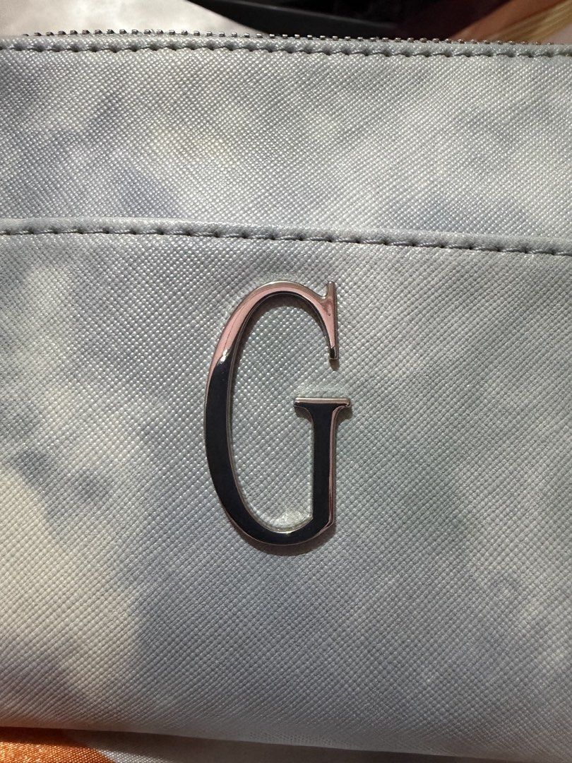 Guess Cosmetic Bag Blue Tie Dye (Category: Purses & Pouches) located in La Trinidad. Submitted by ace32010 (Listing ID 1461070938, Image 2). Description: - Cute Guess cosmetic bag - Stylish blue tie-dye pattern - Features a front pocket with the 'G' logo - Includes a convenient wrist strap - Perfect for organizing makeup and small essentials - Great for travel or everyday use.