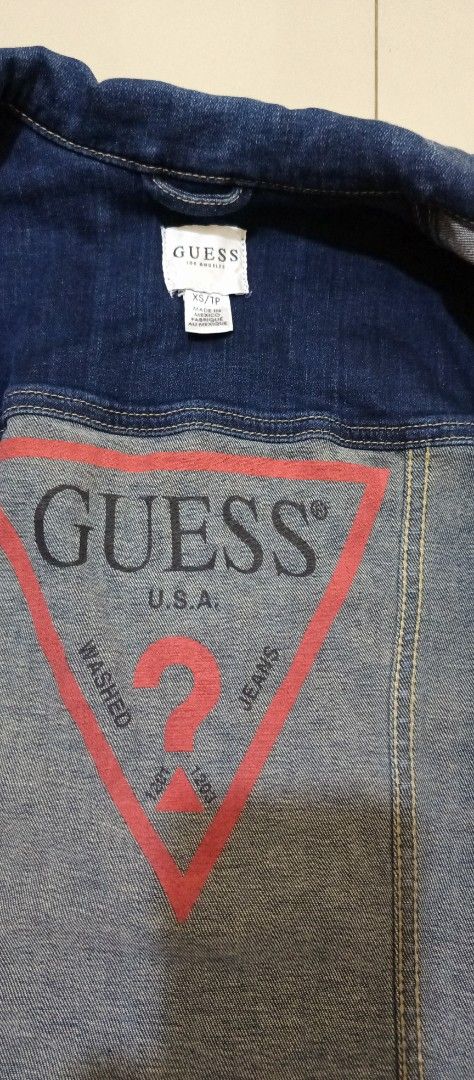 Guess Denim Jacket XS/TP (Category: Coats, Jackets and Outerwear) located in Manila. Submitted by sandobag (Listing ID 1460922230, Image 1). Description: - W 16 L 20 - Excellent condition - Color rate :10/10 - Classic blue denim jacket from Guess - Iconic red triangle logo on the back - Button-up front with chest pockets - Made in Mexico - Material: 94% Cotton, 4% Elastarell-P, 2% Spandex - Versatile staple piece for any wardrobe.