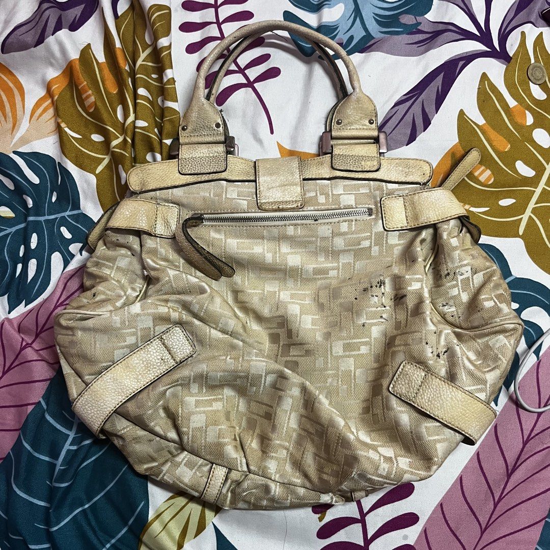 Guess Monogram Shoulder Bag (Category: Luxury Bags & Wallets) located in Caloocan City. Submitted by evermoonlit (Listing ID 1461035889, Image 2). Description: - Cream Guess shoulder bag - All-over monogram pattern - Leather trim and handles - Buckle closures on the front - Top zipper closure - Interior zippered pocket - Note: Some scuffs and marks on fabric, especially on the front.