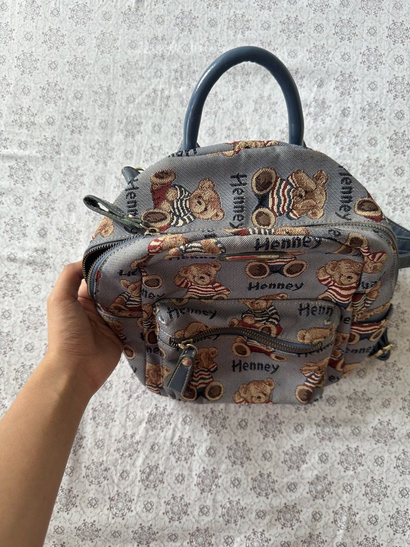 Henney Bear Mini Backpack Teddy Bear Print (Category: Backpacks) located in Quezon City. Submitted by 4k_cam (Listing ID 1460960956, Image 3). Description: - Adorable Henney Bear mini backpack - Includes a convenient top handle - Adjustable shoulder straps for a comfortable fit - Interior pockets for easy organization - Zippers are in excellent working condition - Ideal for everyday use or as a stylish accessory.