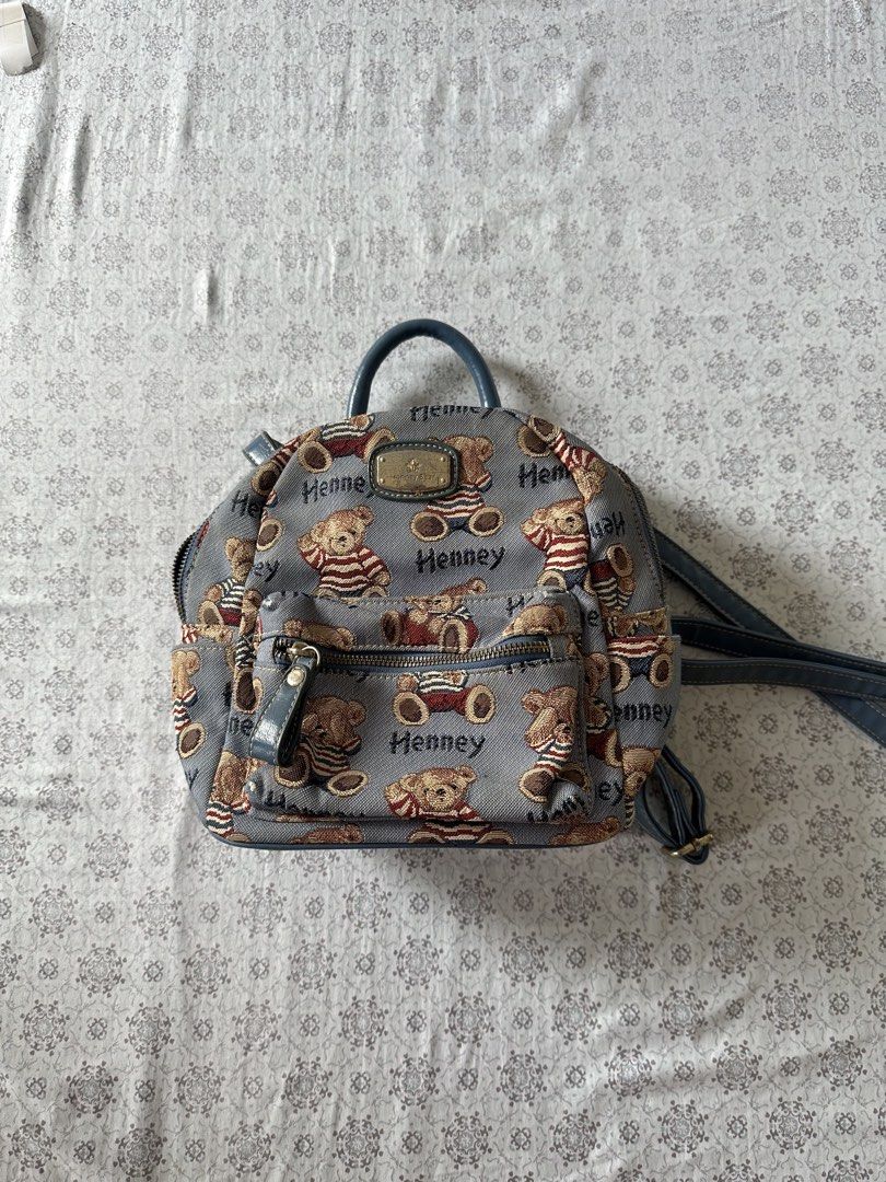 Henney Bear Mini Backpack Teddy Bear Print (Category: Backpacks) located in Quezon City. Submitted by 4k_cam (Listing ID 1460960956, Image 1). Description: - Adorable Henney Bear mini backpack - Includes a convenient top handle - Adjustable shoulder straps for a comfortable fit - Interior pockets for easy organization - Zippers are in excellent working condition - Ideal for everyday use or as a stylish accessory.