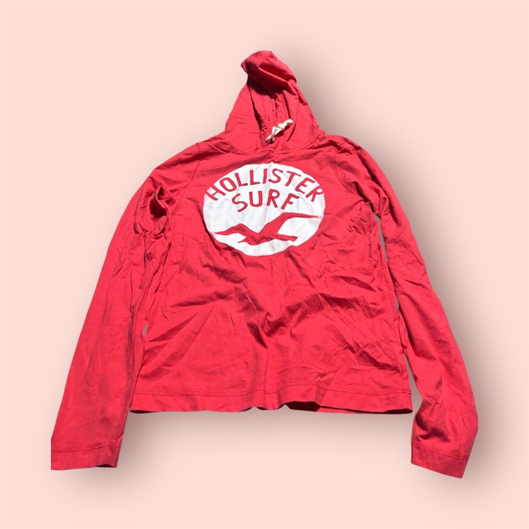 Hollister Surf Hoodie (Category: Coats, Jackets and Outerwear) located in Rosario. Submitted by preloveditems2002 (Listing ID 1461048199, Image 1). Description: - Red Hollister hoodie - Classic surf logo on front - Long sleeves - Drawstring hood - Ideal for casual wear or beach days - Versatile: pairs easily with jeans or shorts - Comfortable and stylish addition to your wardrobe.