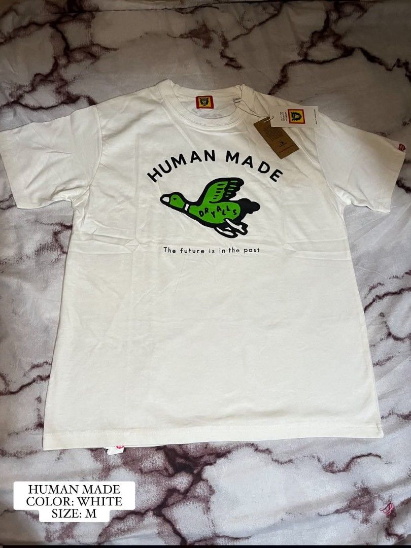 Premium Human Made White Duck T-Shirt Size M (Category: Tshirts & Polo Shirts ) located in Binan City. Submitted by milleeboutique (Listing ID 1461111802, Image 1). Description: - Human Made T-shirt - Color: White - Size: Medium (M) - Features iconic duck graphic - Includes 'DRYALLS' and 'The future is in the past' text - Brand new with tags attached.