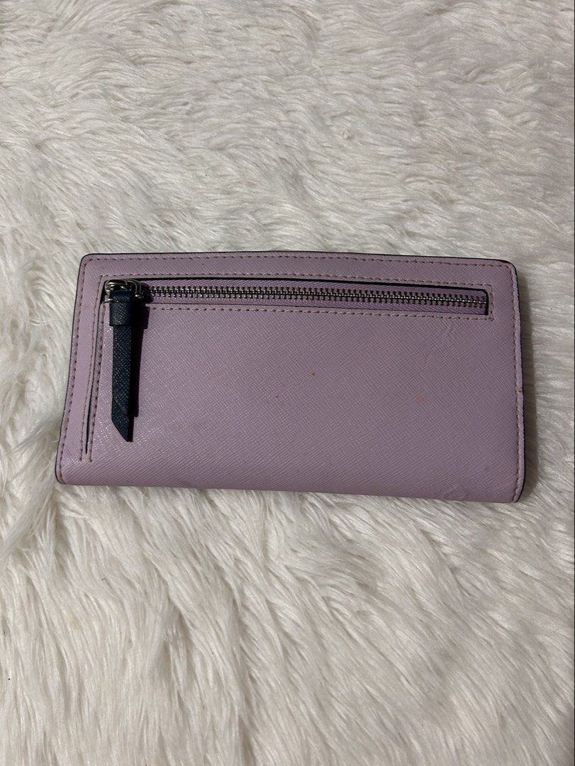 Kate Spade Cameron Slim Bifold Wallet (Category: Wallets & Card holders) located in Cavite. Submitted by cleanupsale20 (Listing ID 1461055220, Image 2). Description: - Authentic Kate Spade New York wallet - Chic two-tone design: Navy blue and light purple - Convenient back zip pocket for coins or small items - Interior features multiple card slots and a clear ID window - Compact size: Approximately 16cm x 8cm - Ideal for keeping your essentials o