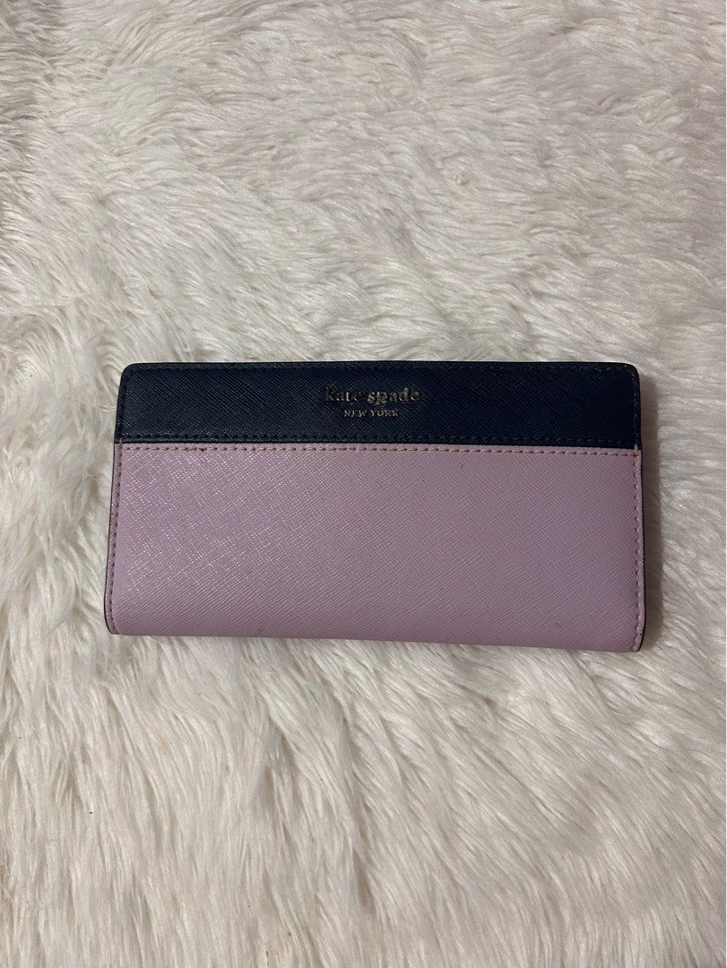 Kate Spade Cameron Slim Bifold Wallet (Category: Wallets & Card holders) located in Cavite. Submitted by cleanupsale20 (Listing ID 1461055220, Image 1). Description: - Authentic Kate Spade New York wallet - Chic two-tone design: Navy blue and light purple - Convenient back zip pocket for coins or small items - Interior features multiple card slots and a clear ID window - Compact size: Approximately 16cm x 8cm - Ideal for keeping your essentials o