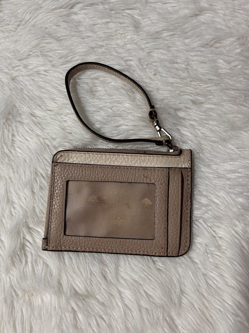 Kate Spade Leila Small Cardholder Wristlet (Category: Wallets & Card holders) located in Cavite. Submitted by cleanupsale20 (Listing ID 1461056056, Image 2). Description: - Stylish Kate Spade card holder - Elegant beige and cream color block design - Convenient zippered compartment for essentials - Clear ID window on the back for easy access - Includes a detachable wrist strap for versatility - Compact dimensions: 11cm x 8cm - Ideal for organizin