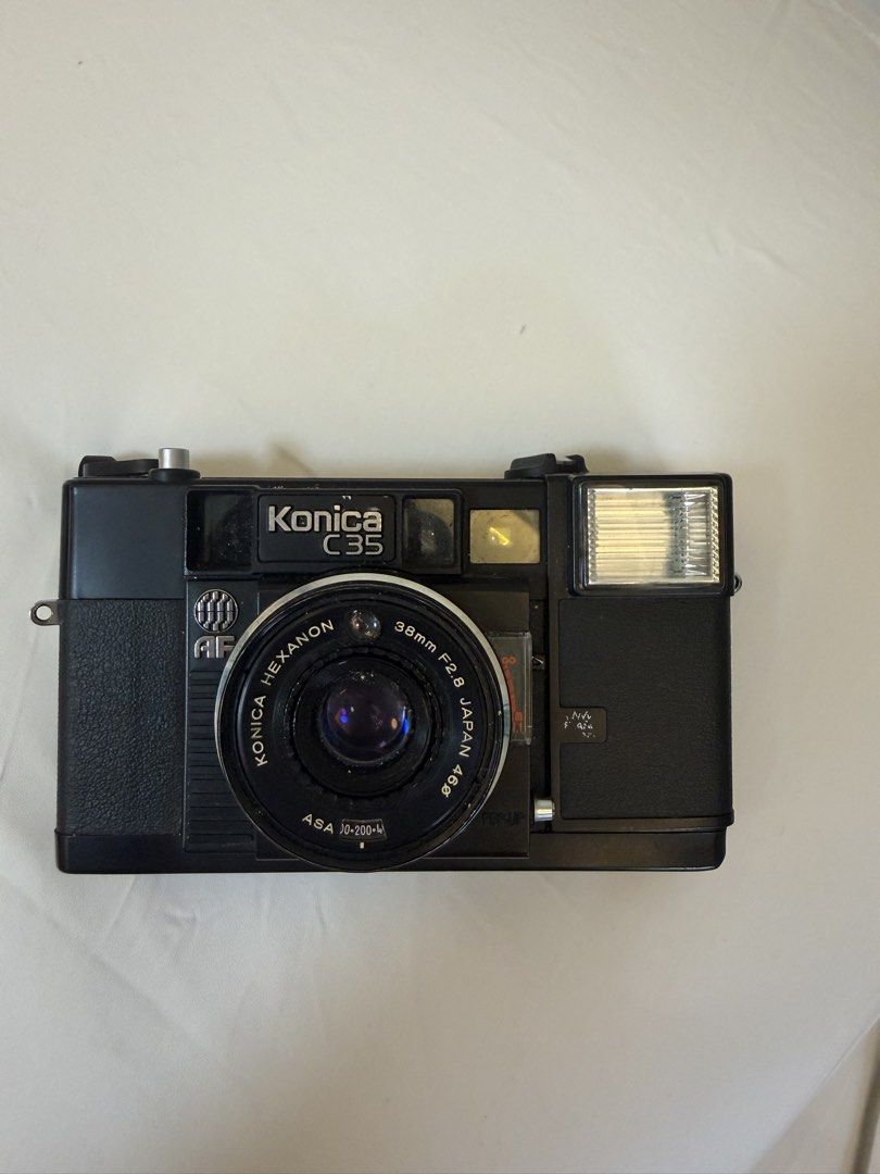 Konica C35 AF (Category: Cameras) located in Manila. Submitted by preloveditemsbym (Listing ID 1460935847, Image 1). Description: 📷 Konica C35 AF Film Camera Condition: Good/used condition • Has some minor scratches from use • Lens is clear • Camera has been tested and is working • Shutter is working • Film rewind is working • Flash is working — needs a few minutes to charge until the red indicator turns on • Battery compartment may need tape to