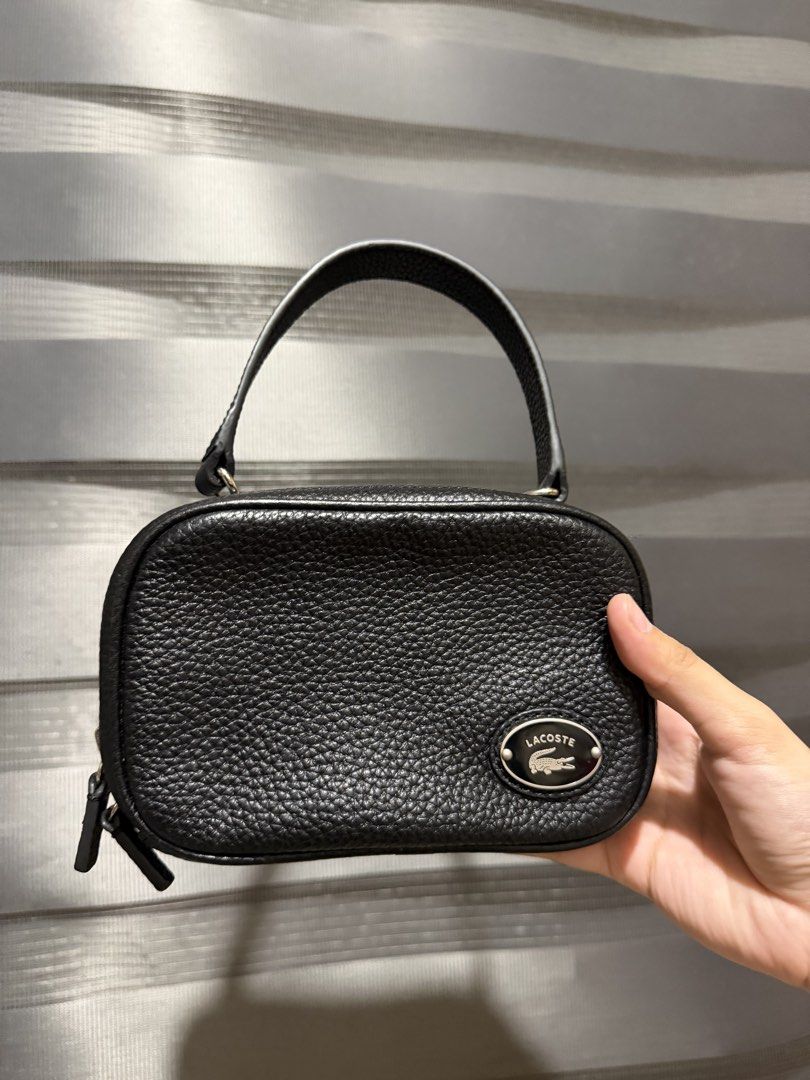 Lacoste Leather Crossbody Bag with Chain Strap (Category: Cross-body Bags) located in Muntinlupa City. Submitted by biancaagbscloset (Listing ID 1461107092, Image 2). Description: Like new condition - Authentic Lacoste black leather crossbody bag - Features a pebbled texture - Silver chain strap (adjustable for shoulder or crossbody wear) - Interior zipped pocket for secure storage - Small and compact, perfect for essentials - Clean inside and ou
