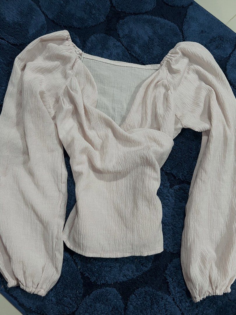 Light Pink Puff Sleeve Wrap Top (Category: Blouses) located in Abucay. Submitted by pmuffy24 (Listing ID 1461103318, Image 1). Description: - Cute light pink top - Features puff sleeves - Stylish wrap front design - Textured fabric for a unique look - Versatile: pairs well with shorts or jeans - Ideal for casual days or nights out with friends.