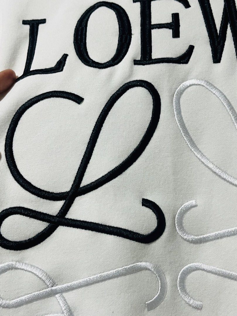LOEWE White Embroidered Logo Crewneck Sweatshirt (Category: Coats, Jackets and Outerwear) located in Mandaue City. Submitted by chuchi152615 (Listing ID 1461098533, Image 3). Description: - White LOEWE Sweatshirt - Features iconic embroidered LOEWE anagram logo - Classic crewneck design - Ribbed cuffs and hem for a comfortable fit - Perfect for stylish everyday wear.