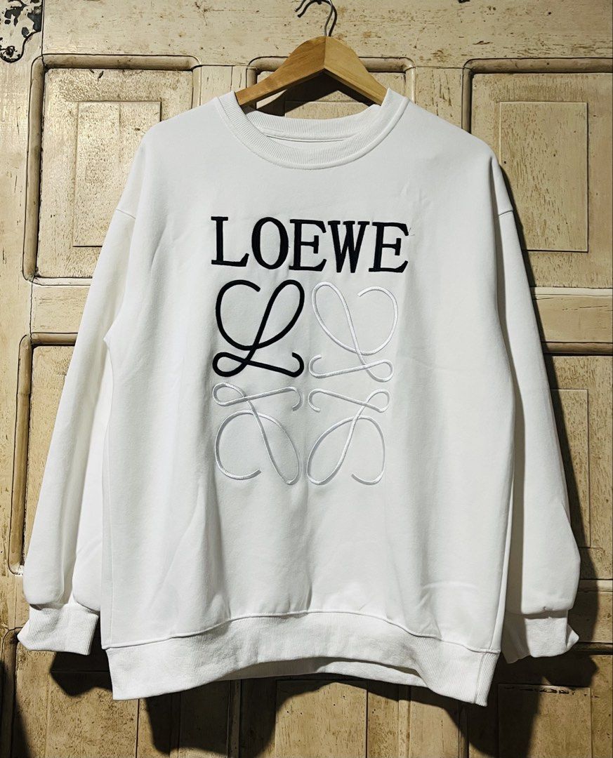 LOEWE White Embroidered Logo Crewneck Sweatshirt (Category: Coats, Jackets and Outerwear) located in Mandaue City. Submitted by chuchi152615 (Listing ID 1461098533, Image 1). Description: - White LOEWE Sweatshirt - Features iconic embroidered LOEWE anagram logo - Classic crewneck design - Ribbed cuffs and hem for a comfortable fit - Perfect for stylish everyday wear.