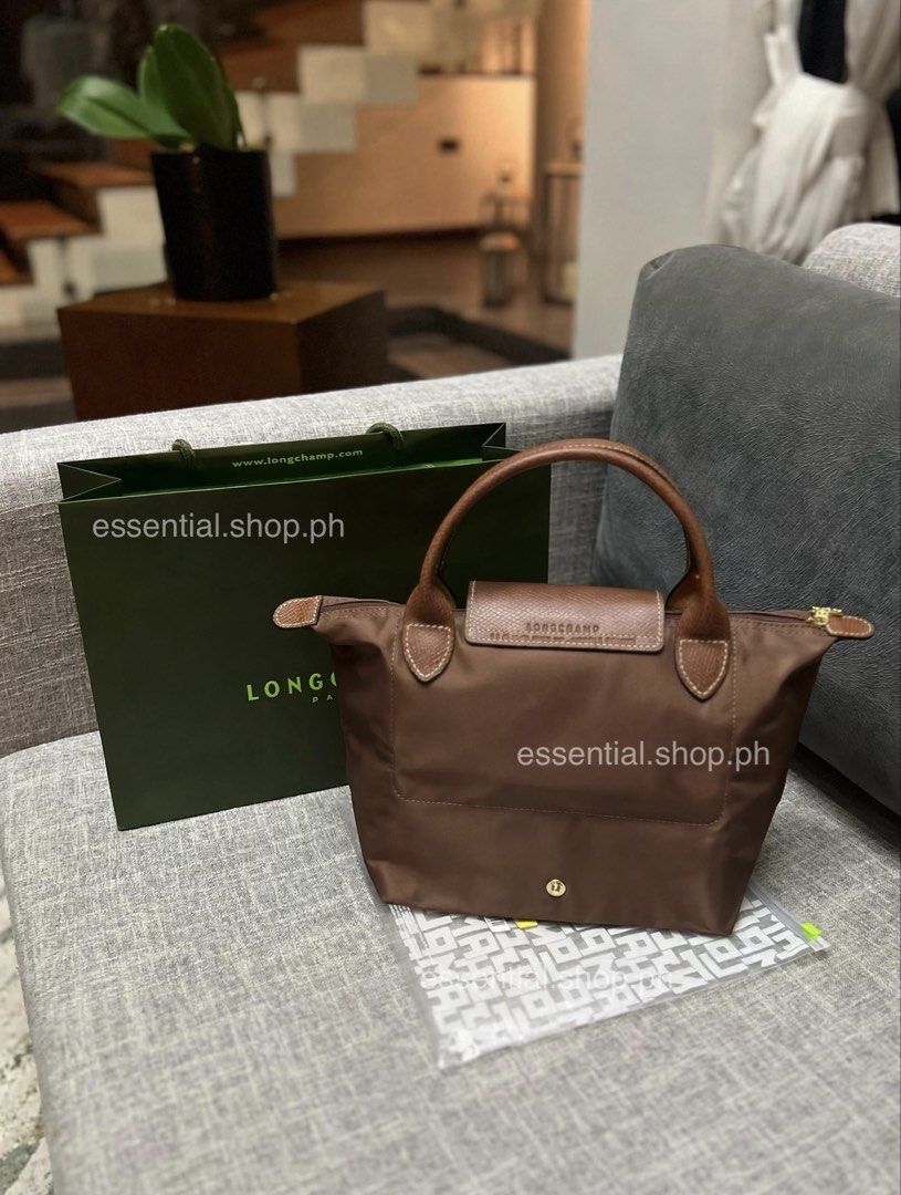 Longchamp Le Pliage Original Small Short Handle Bag Mocha (Category: Luxury Bags & Wallets) located in Manila. Submitted by essential.shop.ph (Listing ID 1461043728, Image 3). Description: PREORDER. 7-10 days ETA. ☺️ Longchamp Le Pliage Original Small Short Handle Mocha ***Actual color difficult to capture. Changes due to lighting. Includes care card, LGP zip lock pouch and paper bag. Dimensions 9.1 inches (L - measured at the base of the bag) x 