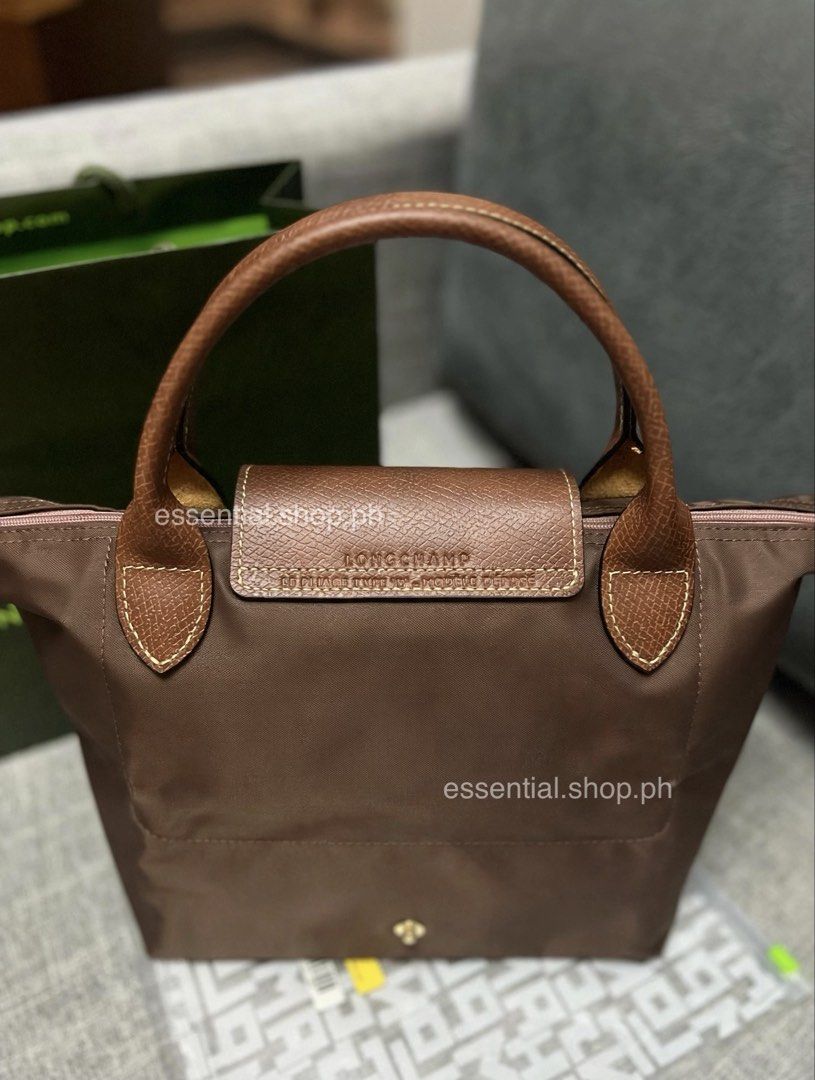 Longchamp Le Pliage Original Small Short Handle Bag Mocha (Category: Luxury Bags & Wallets) located in Manila. Submitted by essential.shop.ph (Listing ID 1461043728, Image 2). Description: PREORDER. 7-10 days ETA. ☺️ Longchamp Le Pliage Original Small Short Handle Mocha ***Actual color difficult to capture. Changes due to lighting. Includes care card, LGP zip lock pouch and paper bag. Dimensions 9.1 inches (L - measured at the base of the bag) x 