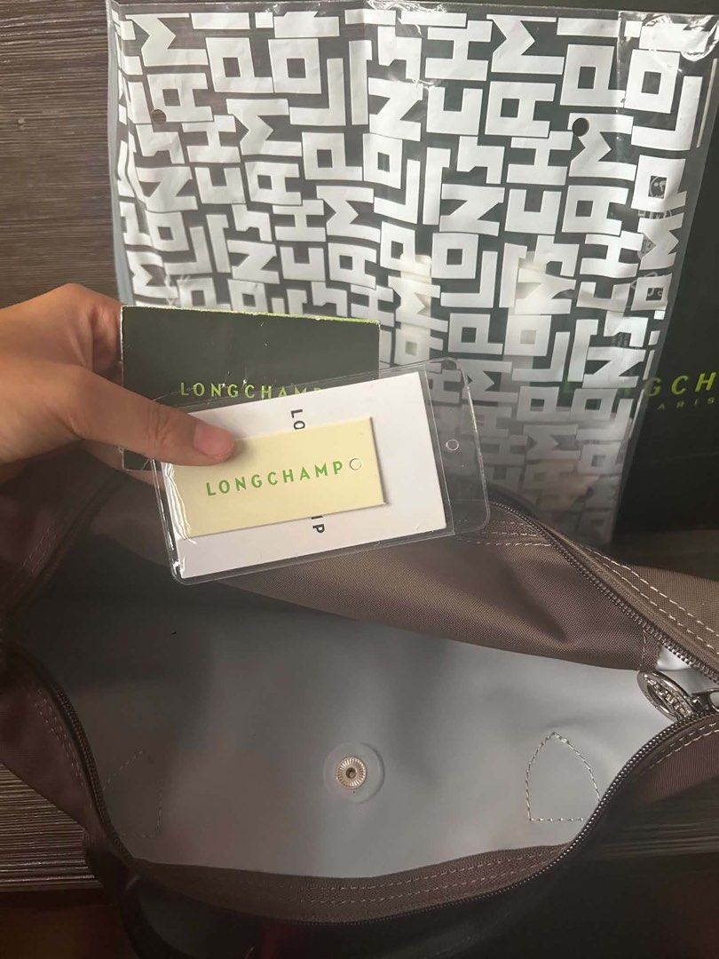 Longchamp Le Pliage Top Handle Bag (Category: Luxury Bags & Wallets) located in Marikina City. Submitted by cristinelinghon12 (Listing ID 1460996729, Image 3). Description: - Brand: Longchamp - Model: Le Pliage - Color: Brown - Size: Small - Condition: Good - Includes: Pink pouch and keychain - Ideal for: Everyday use WITH RECEIPT.