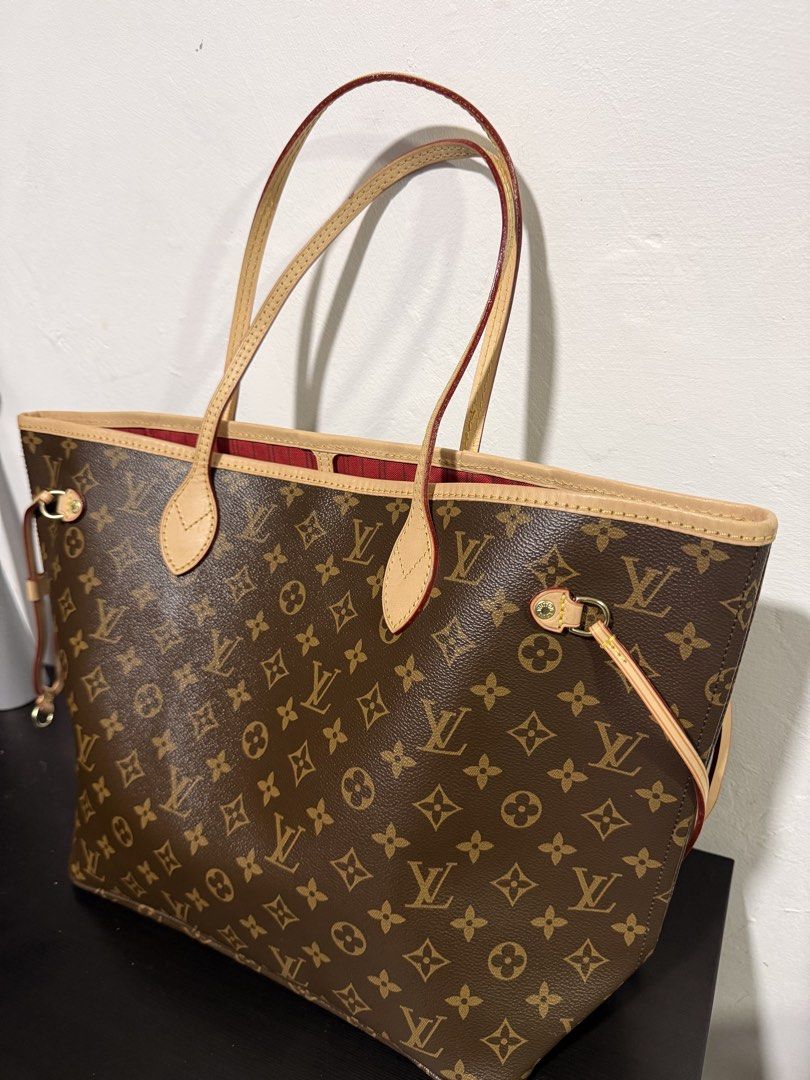 Louis Vuitton Monogram GM Neverfull Tote Bag (Category: Luxury Bags & Wallets) located in Muntinlupa City. Submitted by decluttering.era.alabang (Listing ID 1461037395, Image 2). Description: - Classic Louis Vuitton Neverfull tote - Iconic monogram canvas - Spacious interior with red lining - Durable leather trim and handles - Secure drawstring closure on sides - Ideal everyday bag for your essentials.
