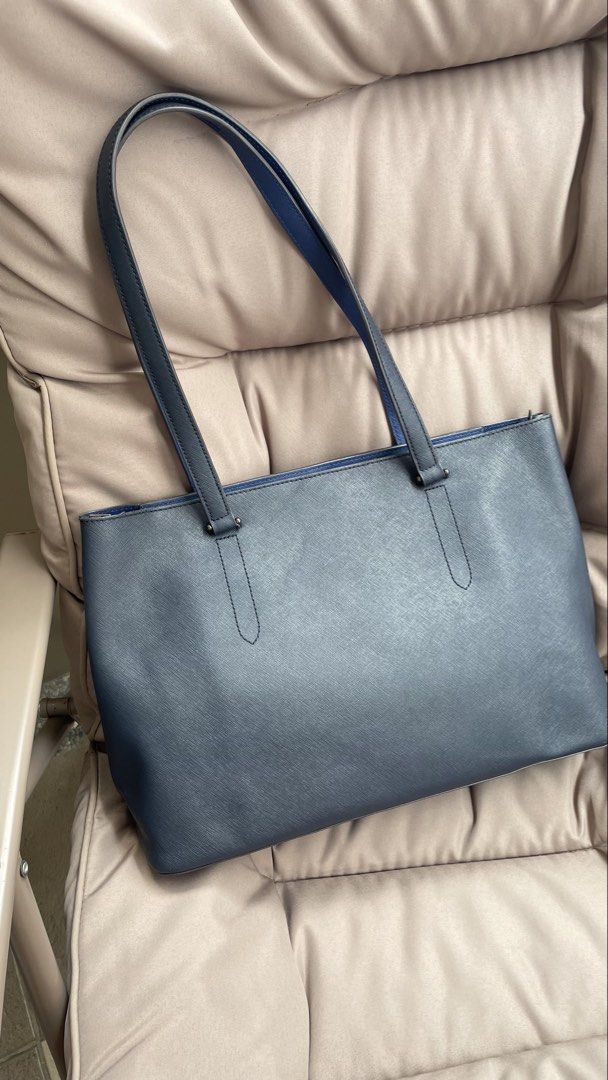 LOVE CAT Navy Blue Tote Bag (Category: Tote Bags) located in Pasig City. Submitted by roseyyylife (Listing ID 1461100530, Image 3). Description: Navy blue tote bag from LOVE CAT. Has a zip closure for the main compartment. Inside, there are zip pockets. The interior is a bright blue. The bag has a textured finish. Handles are navy blue with a blue lining. Measures about 14 inches wide..