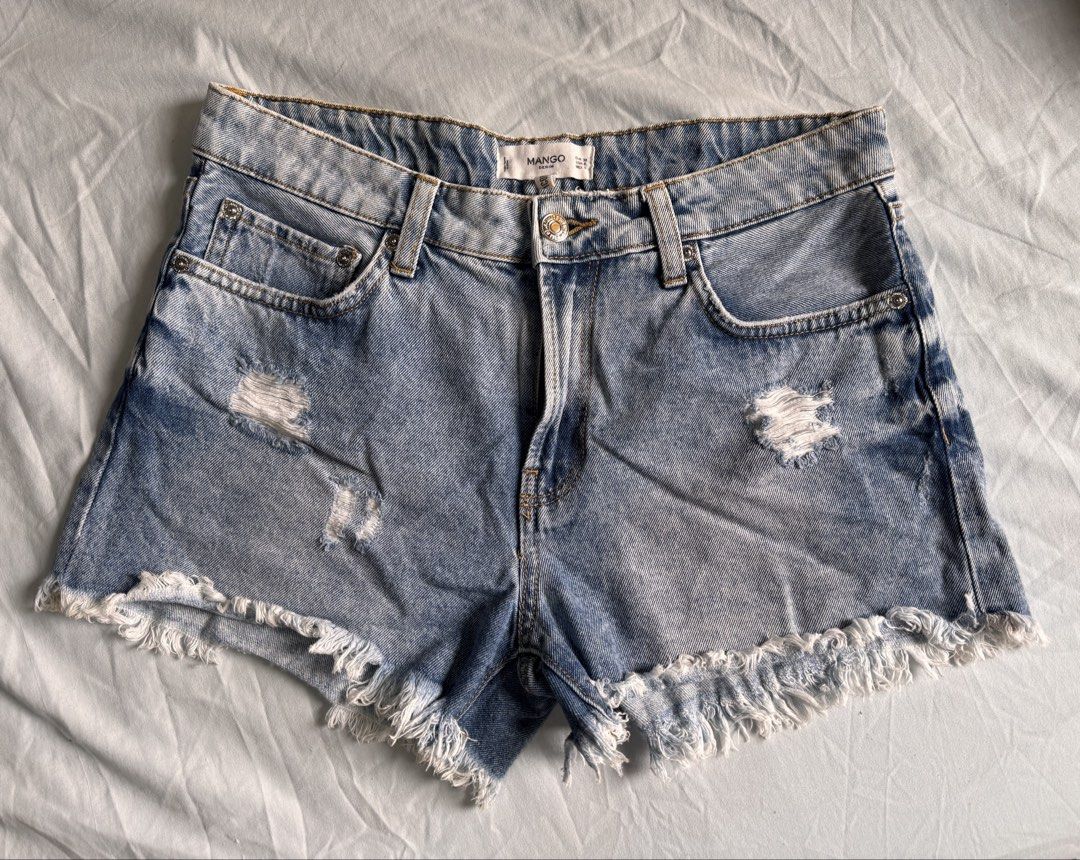 Mango Distressed Denim Shorts with Frayed Hem (Category: Shorts) located in Marikina City. Submitted by 1stuffshop (Listing ID 1460972464, Image 3). Description: - Brand: Mango - Style: Light wash denim shorts - Features: Distressed details, frayed hem - Pockets: Classic five-pocket styling - Closure: Button and zip - Occasion: Casual wear - Versatility: Easy to pair with any top.