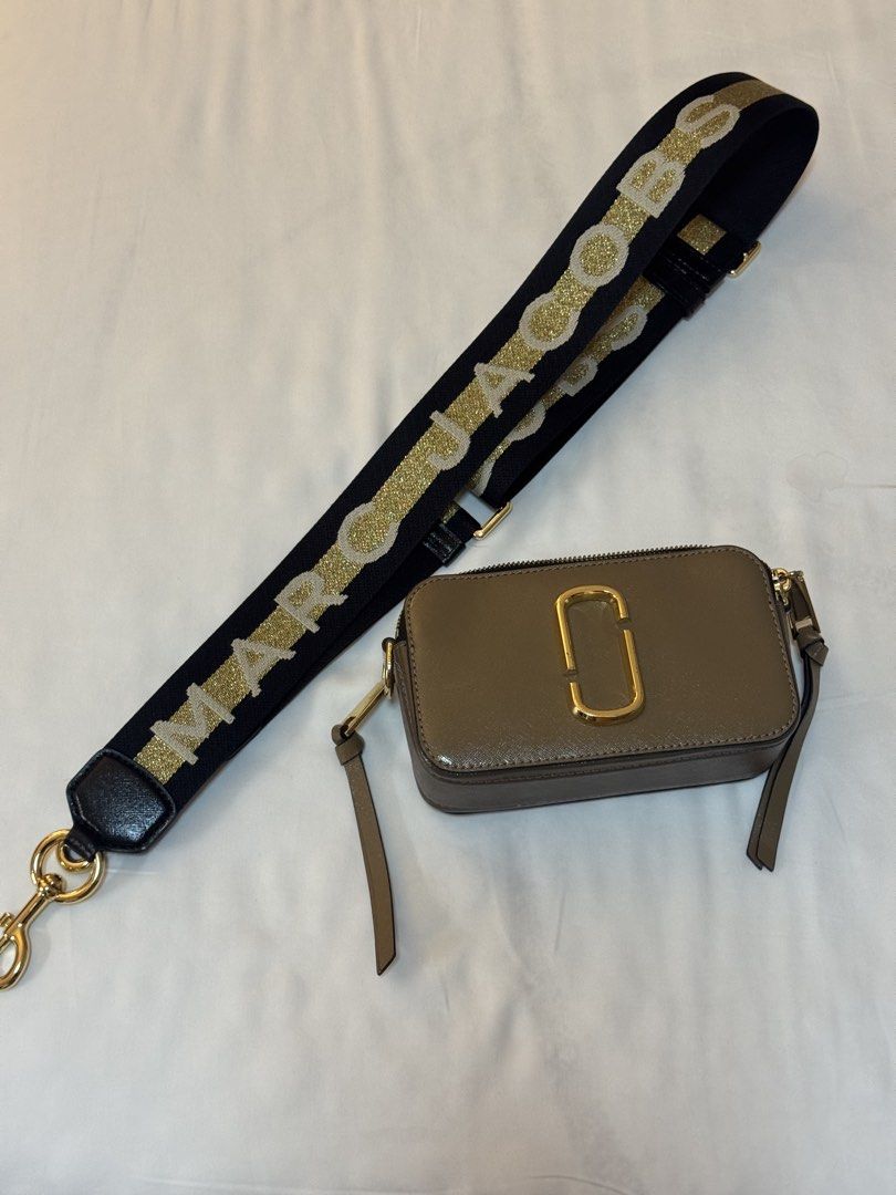 Marc Jacobs Snapshot Camera Bag with Glitter Strap (Category: Luxury Bags & Wallets) located in Manila. Submitted by khatalogue (Listing ID 1460993019, Image 1). Description: - Grey Marc Jacobs Snapshot bag - Comes with black and gold glitter strap - Gold hardware - Zipper closure - Compact size, ideal for essentials - Versatile wear: crossbody or shoulder.