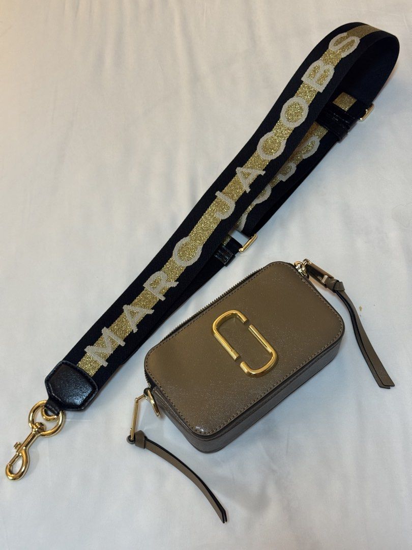 Marc Jacobs Snapshot Camera Bag with Glitter Strap (Category: Luxury Bags & Wallets) located in Manila. Submitted by khatalogue (Listing ID 1460993019, Image 2). Description: - Grey Marc Jacobs Snapshot bag - Comes with black and gold glitter strap - Gold hardware - Zipper closure - Compact size, ideal for essentials - Versatile wear: crossbody or shoulder.