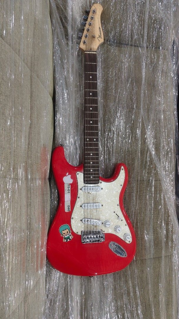 Mavis Red Electric Guitar with Stickers (Category: Musical Instruments) located in Manila. Submitted by joshespino71762 (Listing ID 1460927879, Image 1). Description: - Red Mavis electric guitar - Features fun stickers, including a monkey skull - White pearloid pickguard - Three single-coil pickups - Volume and tone knobs included - Ideal for beginners or those seeking a unique look.