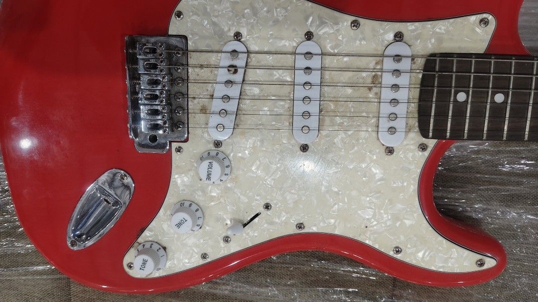 Mavis Red Electric Guitar with Stickers (Category: Musical Instruments) located in Manila. Submitted by joshespino71762 (Listing ID 1460927879, Image 3). Description: - Red Mavis electric guitar - Features fun stickers, including a monkey skull - White pearloid pickguard - Three single-coil pickups - Volume and tone knobs included - Ideal for beginners or those seeking a unique look.
