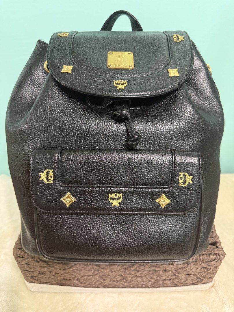 MCM Black Leather Backpack with Gold Hardware (Category: Backpacks) located in Davao. Submitted by annabrd0710 (Listing ID 1461038277, Image 1). Description: - Classic MCM backpack in black leather - Iconic MCM logo and gold-tone hardware - Secure drawstring closure with a flap top - Convenient front pocket for easy access - Adjustable shoulder straps for personalized comfort - Authentic from Germany - No issues.