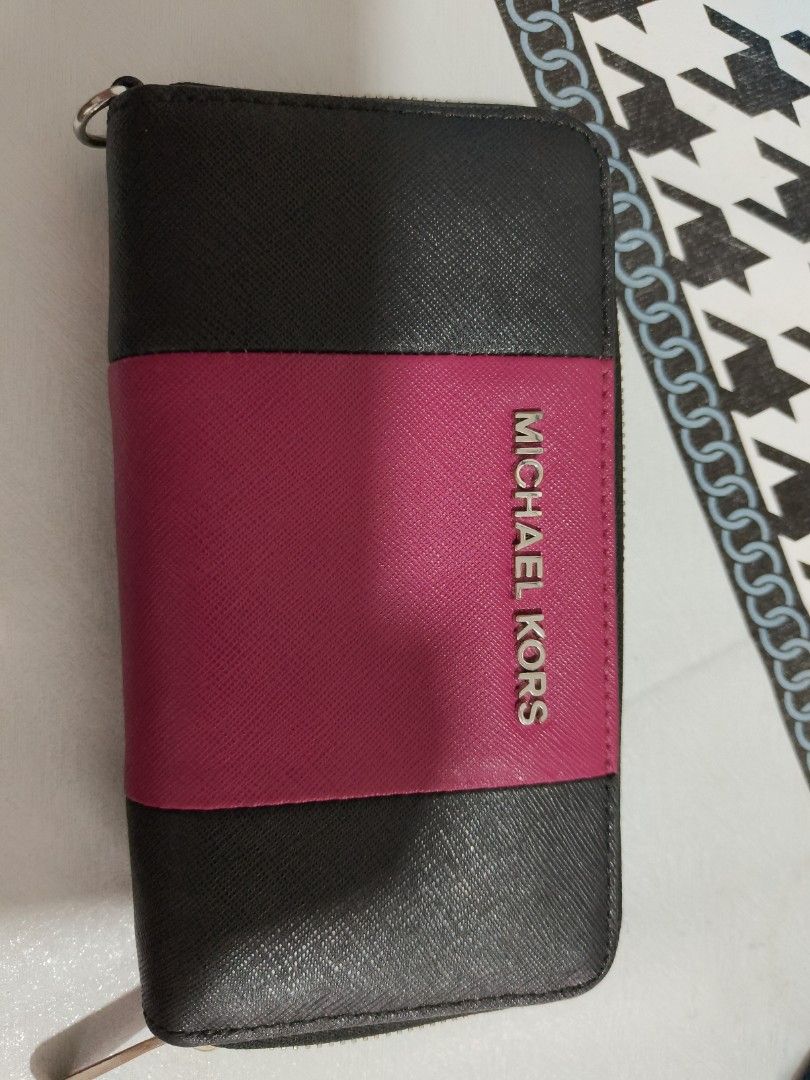 Michael Kors Zip Around Wallet (Category: Wallets & Card holders) located in Caloocan City. Submitted by us_premiumclothes (Listing ID 1460932184, Image 1). Description: - Stylish Michael Kors zip around wallet - Chic black and pink color block design - Ample card slots for all your cards - Interior zippered compartment for secure storage - Features the iconic Michael Kors logo on the zipper pull - Perfect for keeping your essentials organized IS