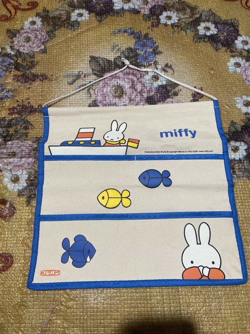 Miffy Fabric Wall Organizer with Pockets (Category: Nursery Lighting & Decor) located in Davao. Submitted by mengsmixitems (Listing ID 1461005966, Image 1). Description: - Adorable Miffy wall organizer featuring Miffy and friends on a ship! - Made of durable fabric with charming blue trim. - Three spacious pockets for storing toys, books, or essentials. - Ideal for organizing a child's room or nursery. - Comes with a rope for easy hanging. - Appr