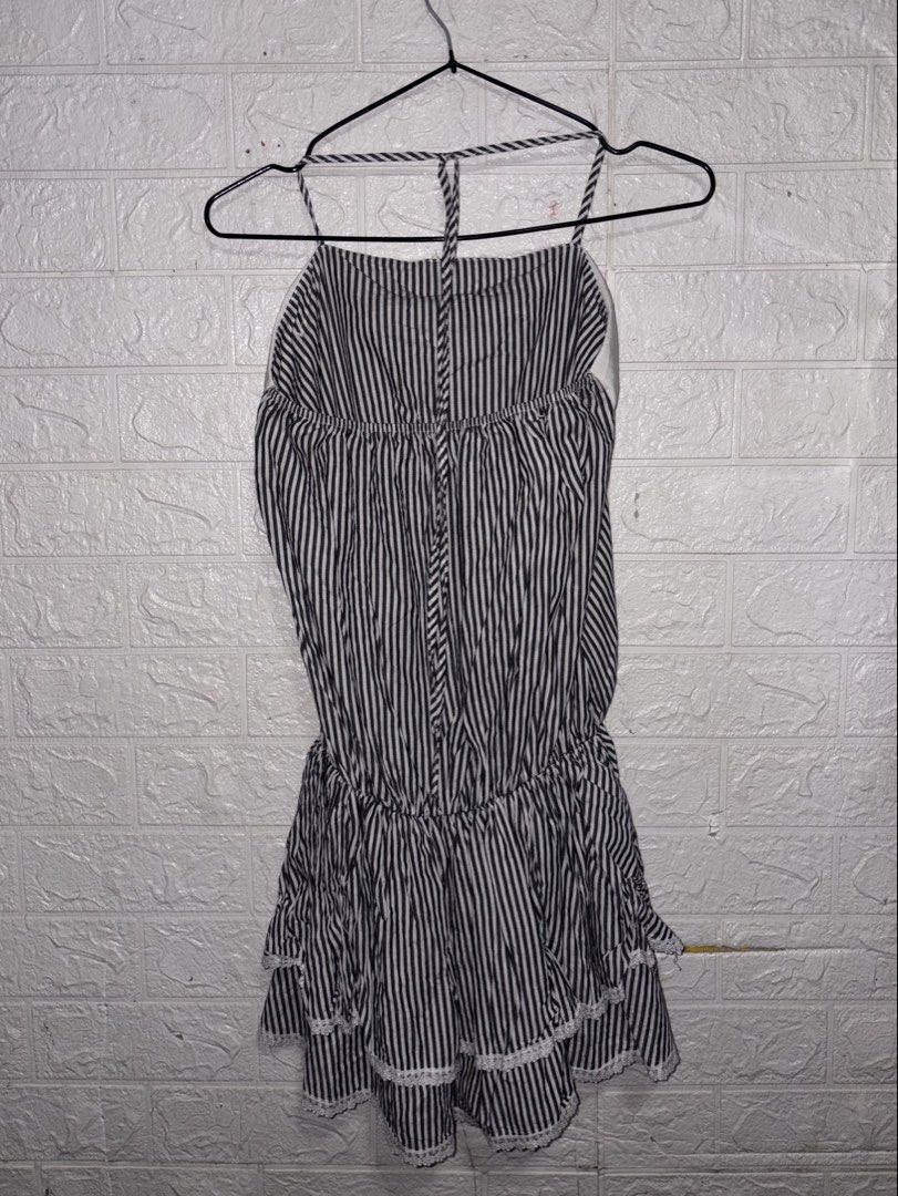Mini Backless Dress (Category: Dresses) located in Manila. Submitted by _noname.shop (Listing ID 1461052279, Image 2). Description: - Mini backless dress - Size: S (US 4 / UK 8 / EU 36) - can fit to Medium - Color: Black and white stripes - Features: Halter neck, backless design, tiered ruffled skirt with lace trim, cinched waist with tie - Condition: 4/5 - Style: Flirty and chic.