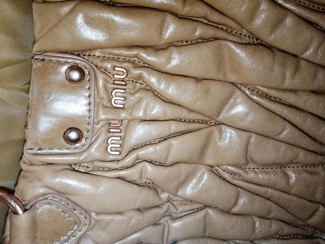 Miu Miu | purple lining | lampo underzip | first edition (Category: Luxury Bags & Wallets) located in Santa Rosa. Submitted by pure.lilyyy (Listing ID 1460965064, Image 3). Description: - Miu Miu handbag - Made with soft, gathered nappa leather - Features a braided handle - Rose gold hardware - Interior lined with purple satin - Classic Miu Miu design ‼️‼️PLEASE READ BEFORE BUYING‼️‼️ -THE BAG IS CUT LOCK, and has flaws.