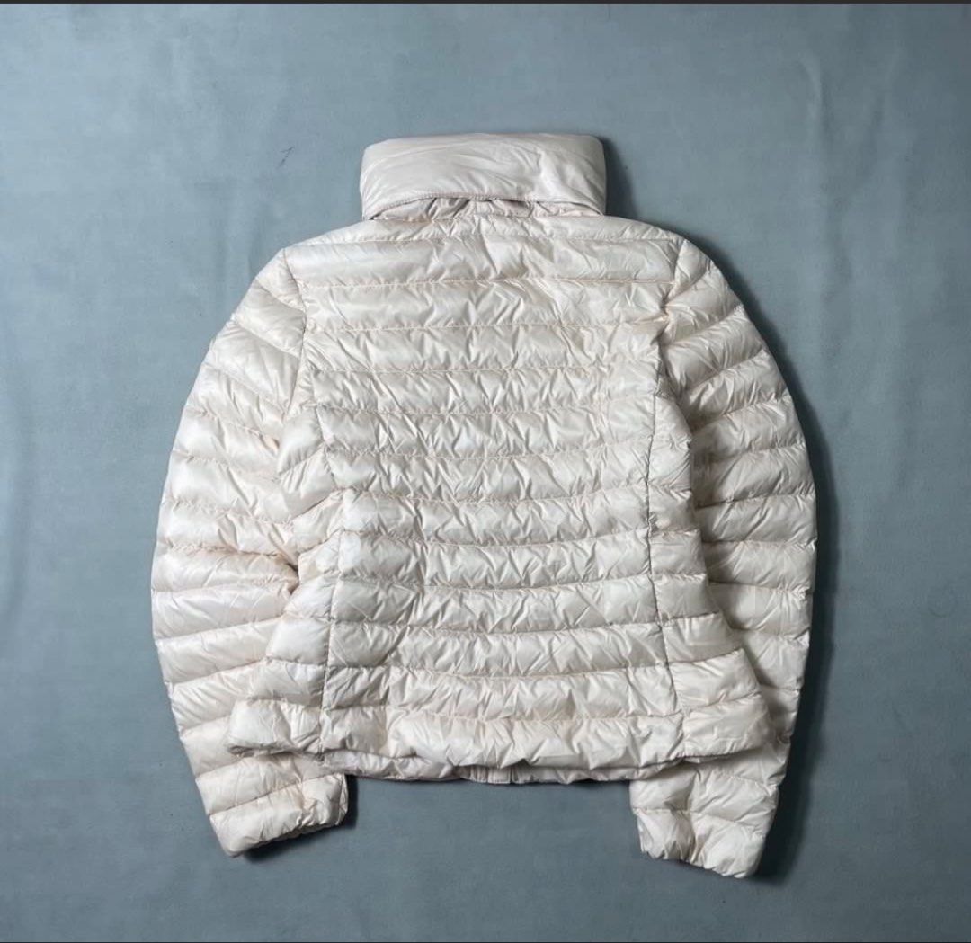 Moncler IGE - Beige Hooded (Category: Coats, Jackets and Outerwear) located in Makati City. Submitted by celfies (Listing ID 1460930968, Image 3). Description: - Beige Moncler puffer jacket - Stand-up collar - Detachable hood - Lightweight and quilted design - Iconic Moncler logo patch on sleeve - Versatile for layering or standalone wear packable Dimension: tagged size: 153cm Length : 21 Width : 16.5 Shoulder: 14 Sleeve: 23 Almost New.