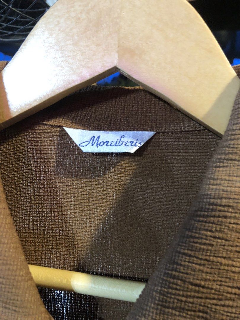 Moreiberis Brown Collared Button-Up Blouse (Category: Blouses) located in Cauayan City . Submitted by wholly.craaaft (Listing ID 1461018510, Image 2). Description: - Brown collared blouse from Moreiberis - Textured fabric - Button-up front - Black trim detail on collar - Long sleeves with button cuffs - Ideal for smart casual looks - Versatile: pairs well with skirts or trousers.